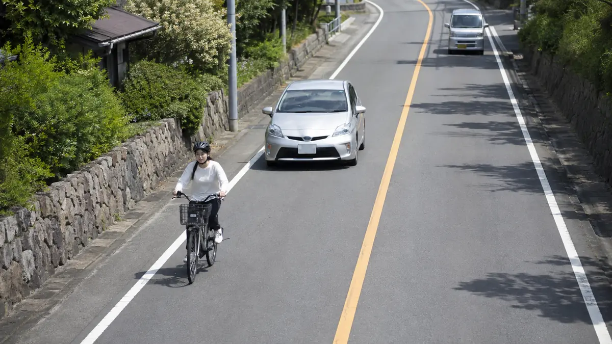 黄色いセンターラインと自転車の追い越し 黄色いセンターラインを越えずに自転車の後方で追い越しを待つ自動車